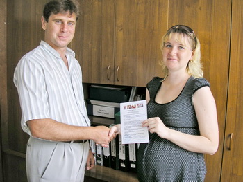 Председатель комитета по делам молодежи Евгений Иноземцев вручает жилищный сертификат молодой семье